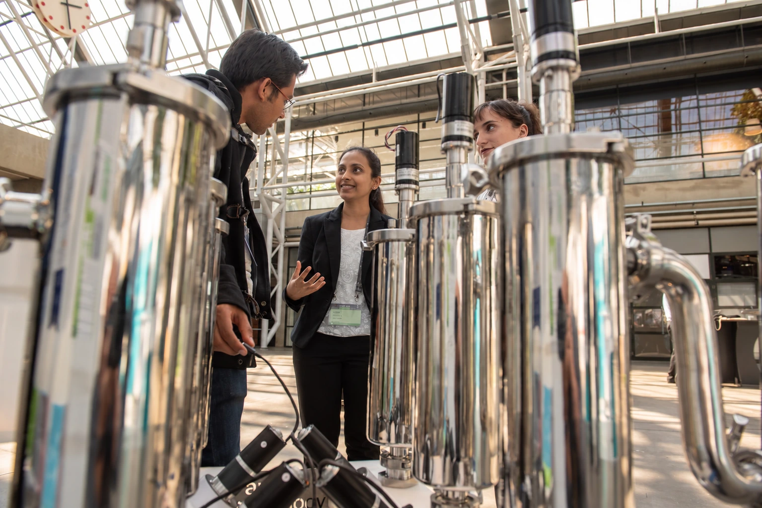 A researcher smiling as she explains Anaero's laboratory reactors to her colleagues